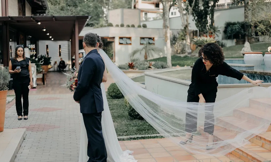 Assessora da Noiva S.A. ajustando o véu da noiva antes da cerimônia