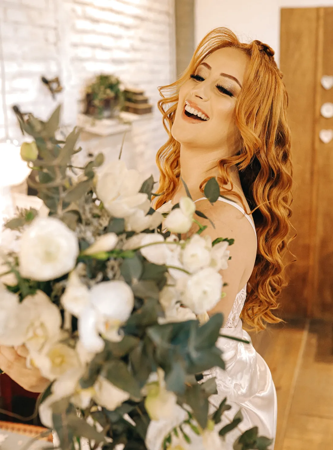 Noiva sorrindo com buquê de flores brancas no dia do casamento